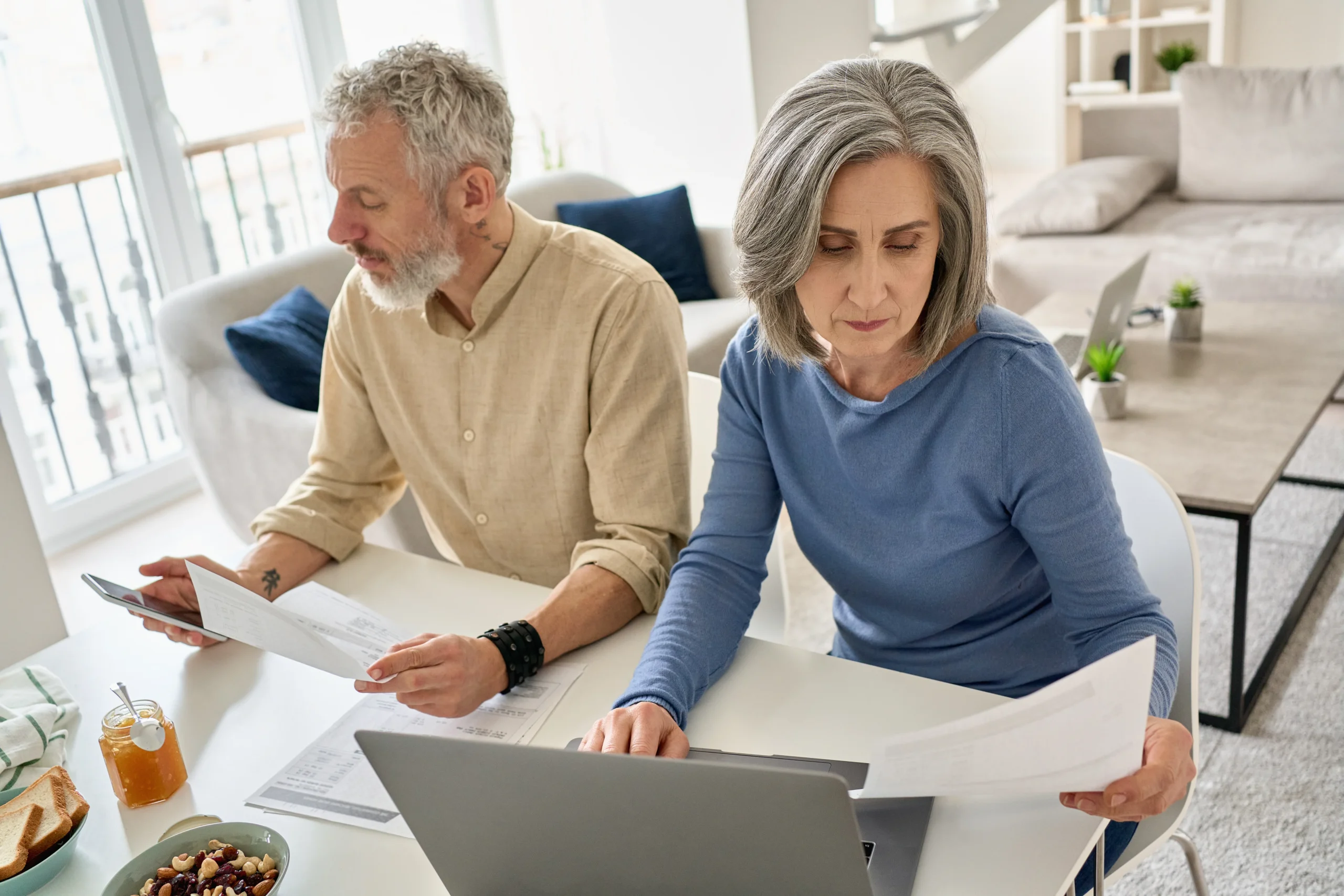 Couple reviewing immigration waiver paperwork together at home with a laptop