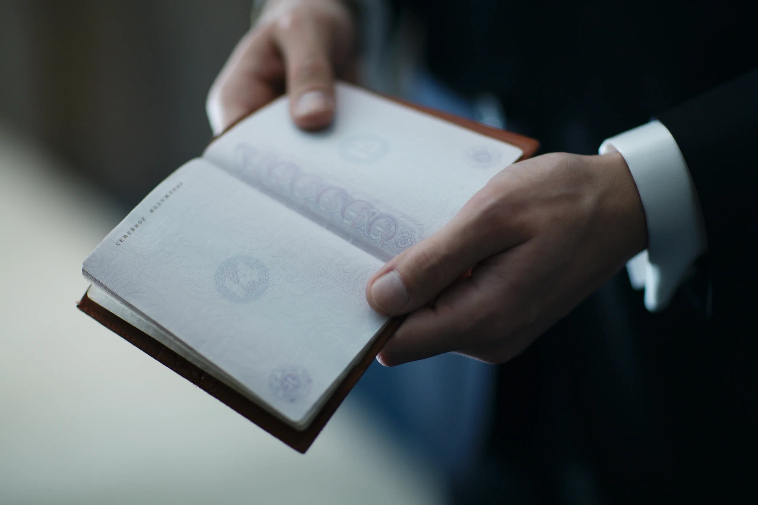 Hands holding an open passport, reflecting the document control many labor and sex trafficking survivors experience