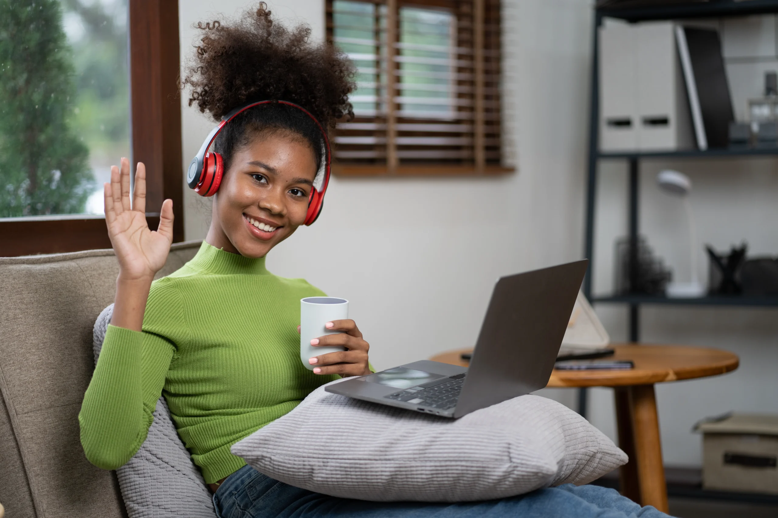 Woman with headphones on a private video call from home during a VAWA evaluation