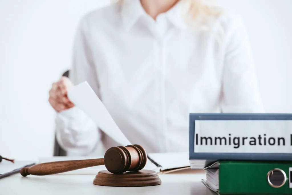 Immigration attorney reviewing an I-601A waiver case with a gavel and immigration law binder