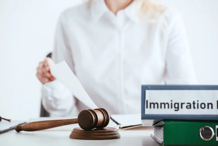 Immigration attorney reviewing an I-601A waiver case with a gavel and immigration law binder