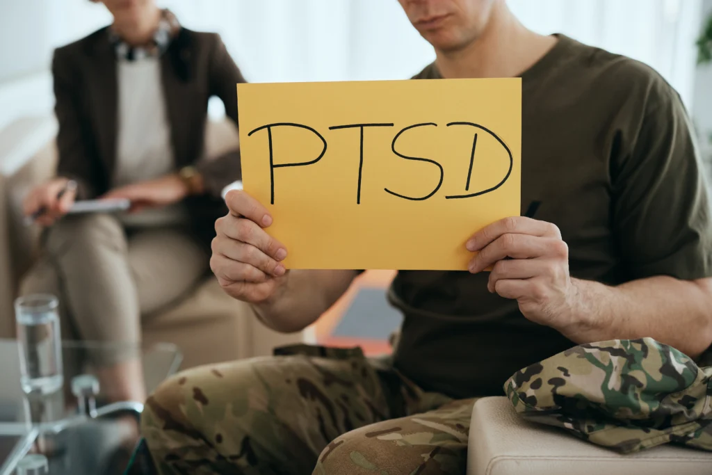 Man holding a PTSD sign during a therapy session discussing trauma and mental health
