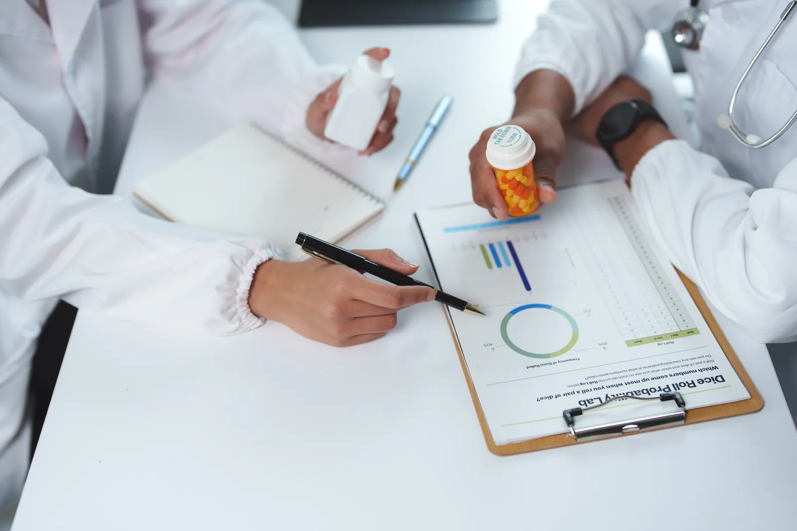 Clinicians reviewing a patient’s medication and progress chart while planning psychiatric medication management