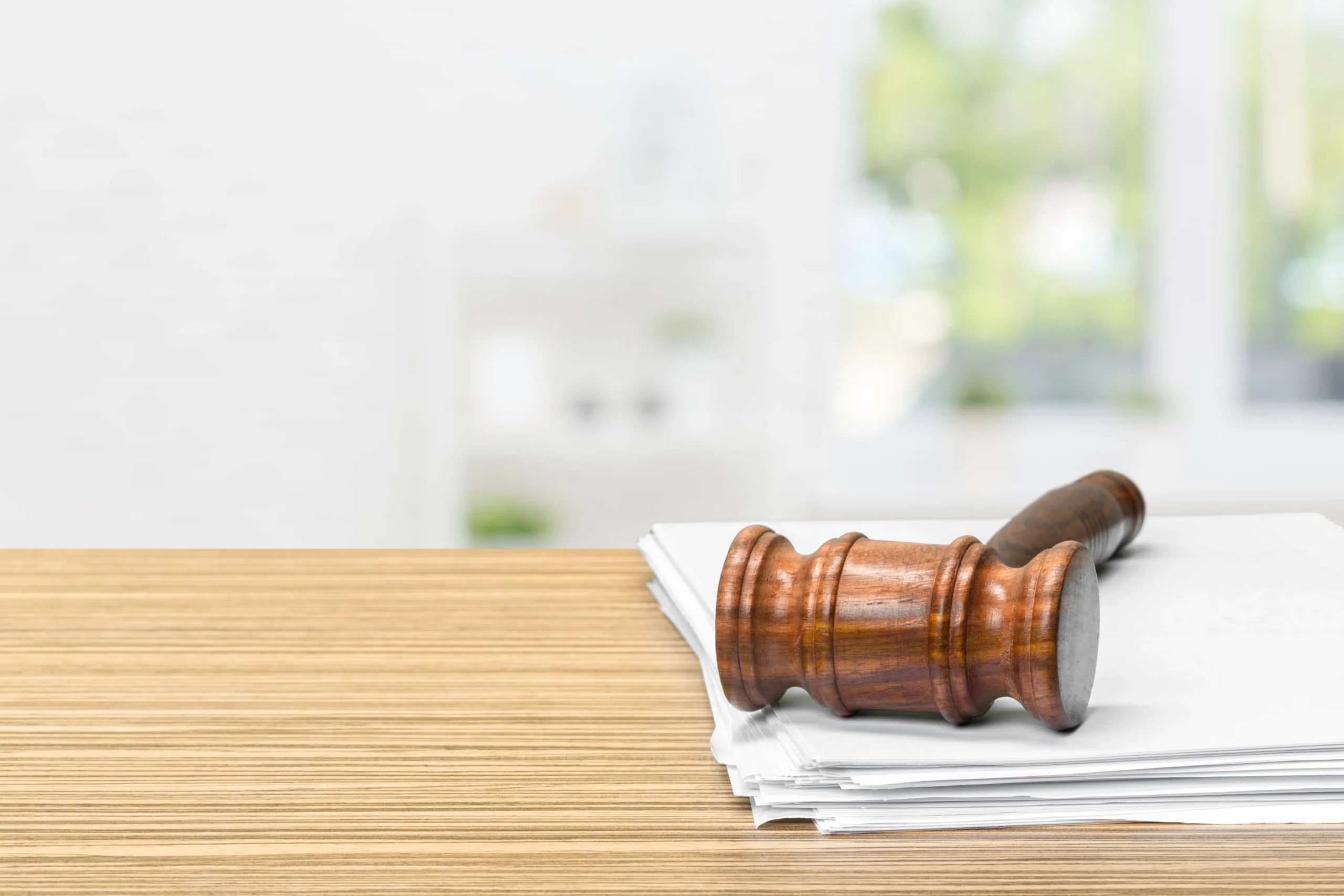 Judge's gavel resting on a stack of case documents, representing psychiatric evaluation reports for immigration attorneys