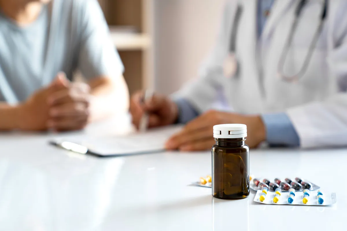 Prescription bottle and medication blister packs on a desk during a psychiatric medication management consultation