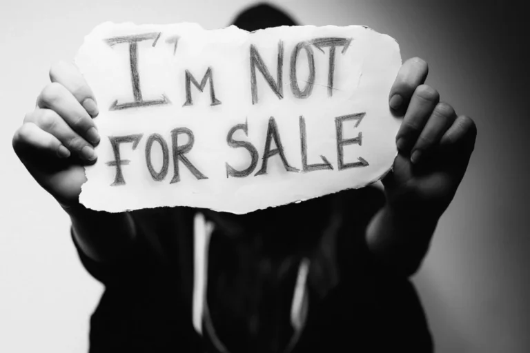 Human trafficking survivor holding an "I'm not for sale" sign, T visa eligibility